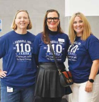 Three Jarrell ISD staff members in blue 110th-anniversary shirts.