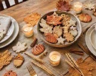 Leaf- and pumpkin-shaped salt-dough ornaments on a harvest table.